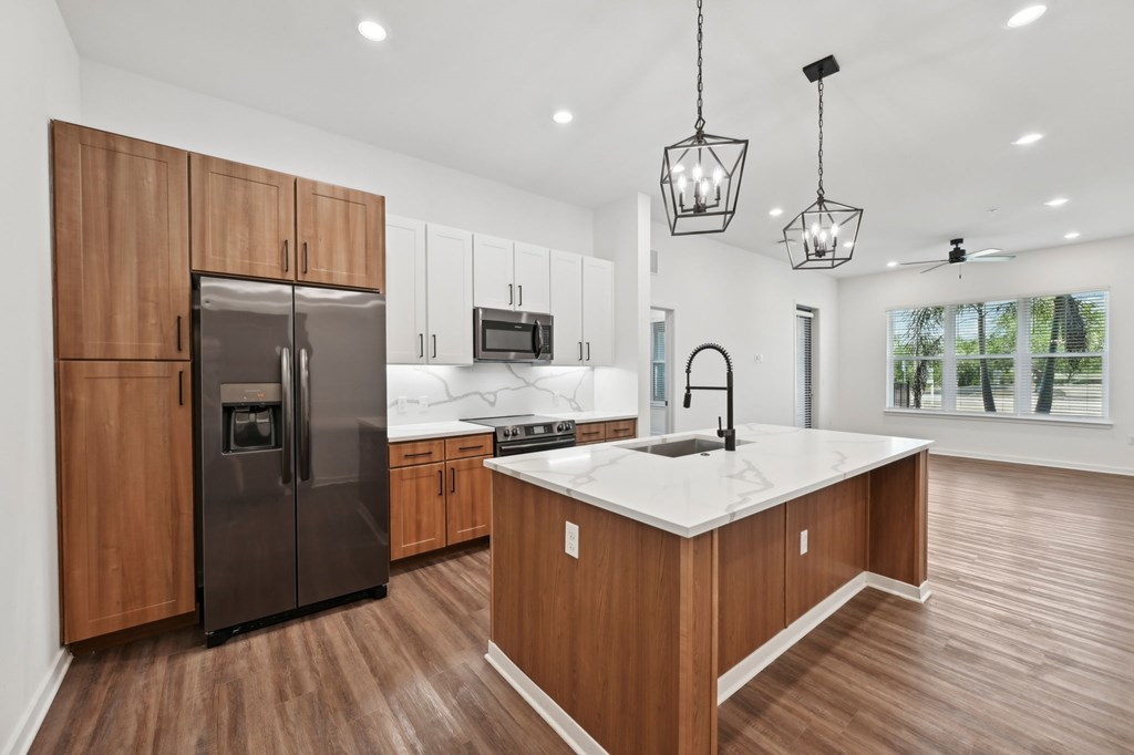A modern kitchen with wooden cabinets at The Concord Luxury Apartments, Sarasota