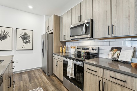 A modern kitchen with wooden cabinets and stainless steel appliances at The Junction at Rockledge Apartments, Rockledge 32955
