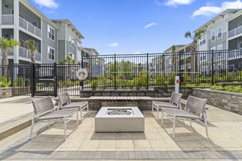 A patio with a fire pit and chairs. at The Quinn Luxury Apartments, Florida