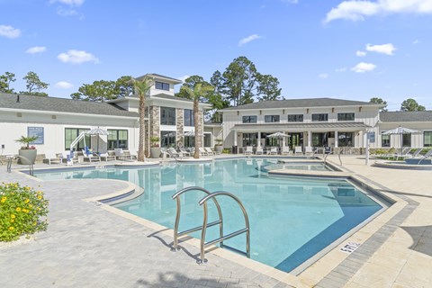 A large swimming pool with a diving board in front of a building.