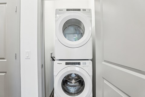A white washing machine and dryer in a laundry room. at The Junction at Rockledge Apartments, Rockledge