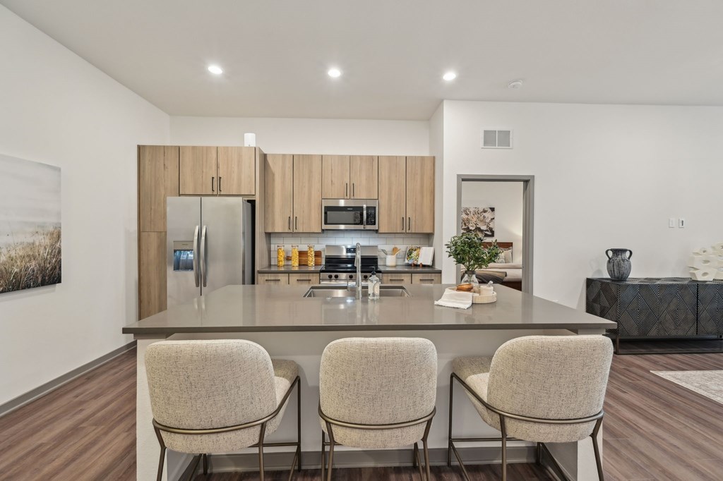 A modern kitchen with a large island and chairs at The Concord Luxury Apartments, Sarasota, FL, 34240