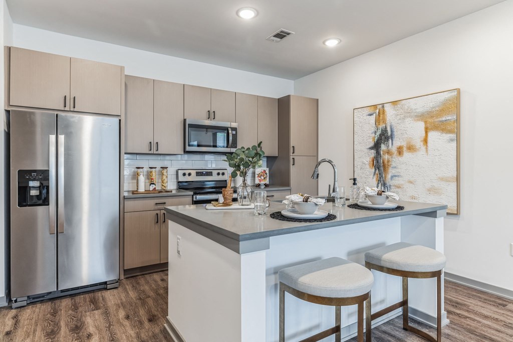a kitchen with a large center island with two stools  at Prism at Diamond Ridge, Moon Township, PA