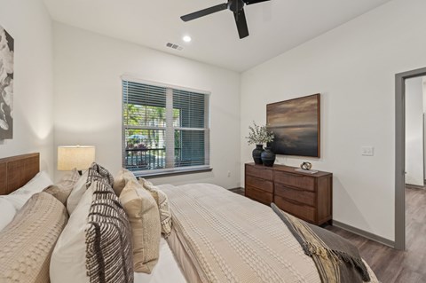 A bedroom with a large bed and a ceiling fan.