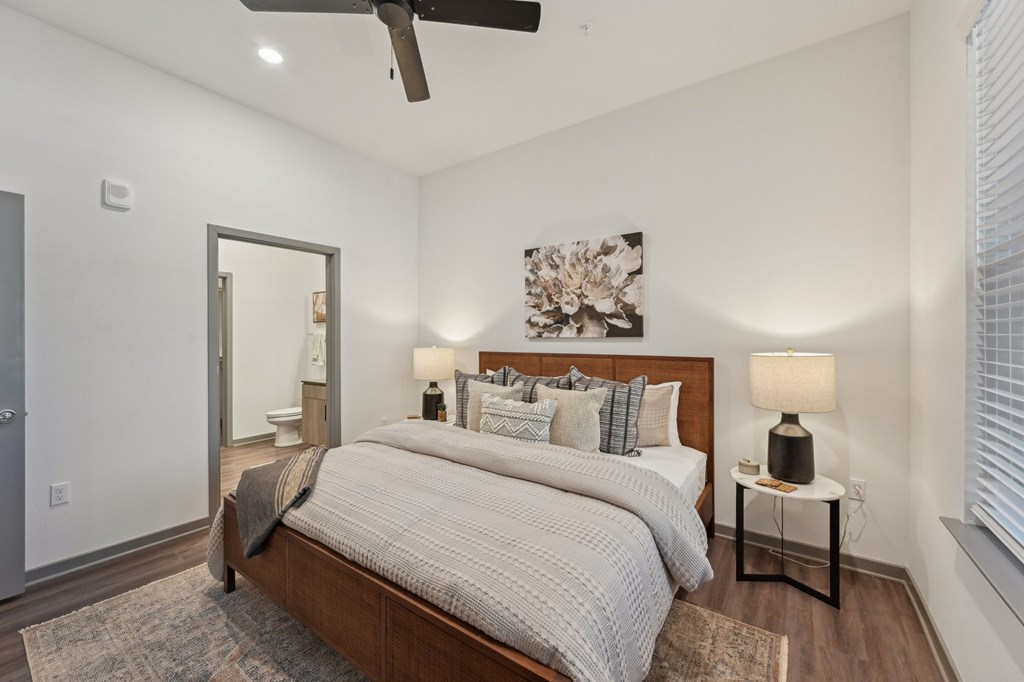 A bedroom with a large bed and a ceiling fan at The Concord Luxury Apartments, Sarasota