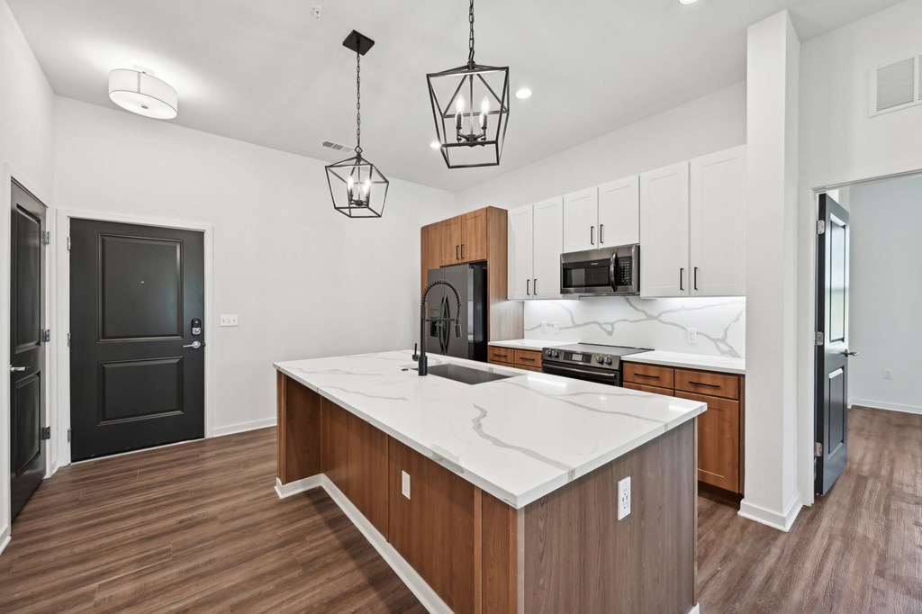 A kitchen with a white countertop and wooden cabinets at The Concord Luxury Apartments, Sarasota, Florida