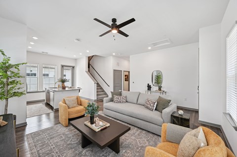 A living room with a grey couch, a brown coffee table, and a ceiling fan.