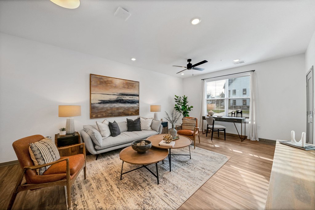 a living room with a couch and chairs and a ceiling fan at The BLVD at Wilson Crossings, Wyoming, MI 49418