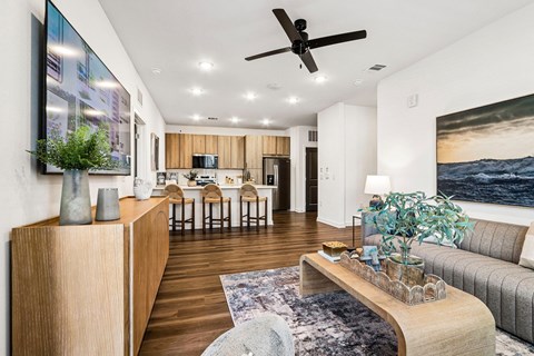 A modern living room with a wooden floor and a large painting on the wall.