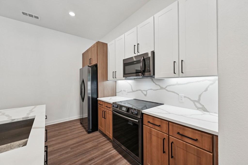 A kitchen with white countertops and wooden cabinets at The Concord Luxury Apartments, Florida, 34240
