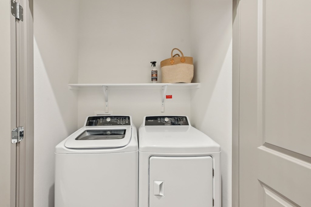 A small laundry room with a washer and dryer at The Concord Luxury Apartments, Sarasota, Florida