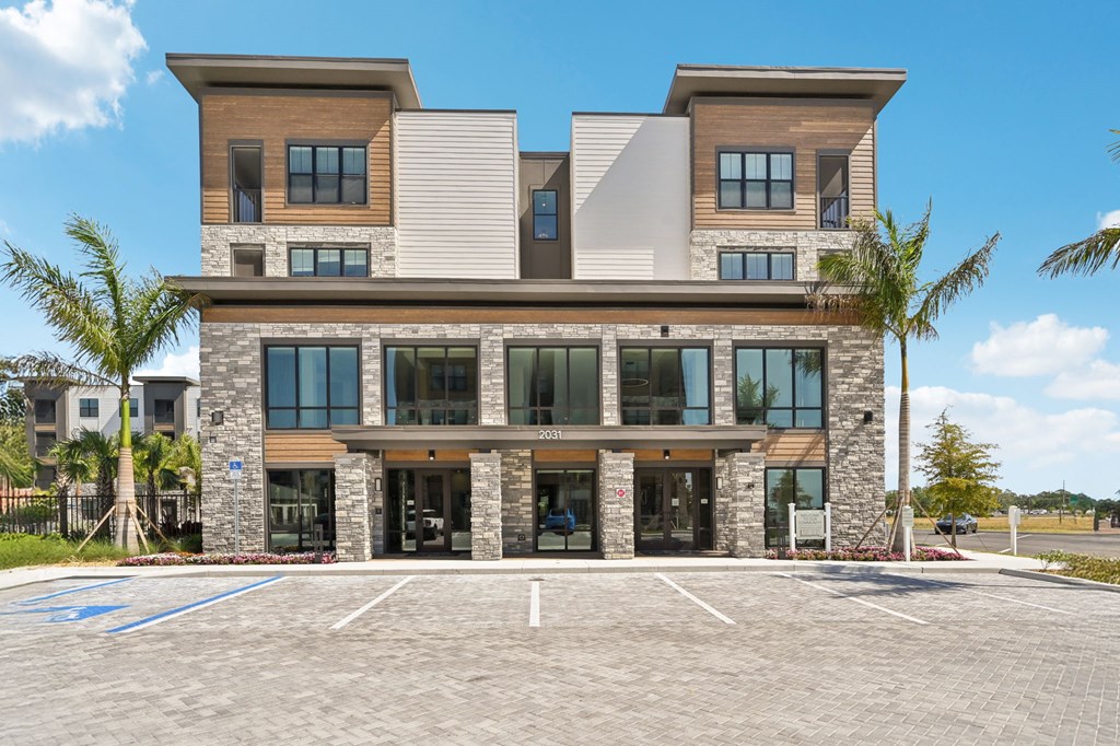 A modern two-story building with a parking lot in front at The Concord Luxury Apartments, Florida, 34240