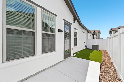 A white house with a green strip of grass in front. at The Hadley - North Port, FL Apartments, North Port