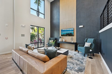 A modern living room with a large sectional sofa and a painting on the wall.