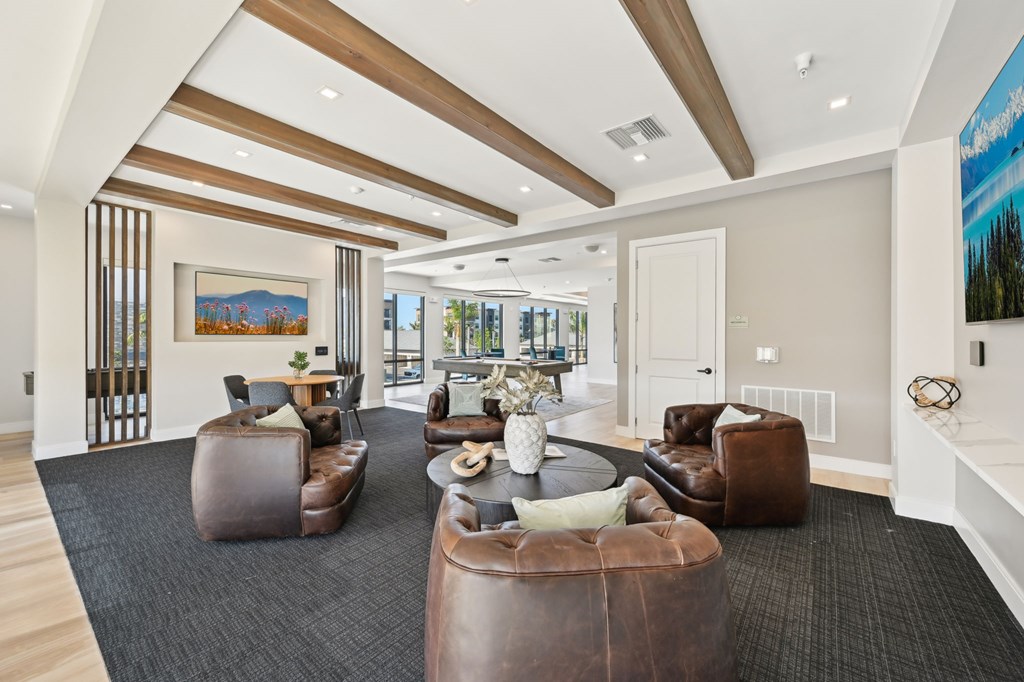 A spacious living room with brown leather furniture and a painting on the wall at The Concord Luxury Apartments, Florida