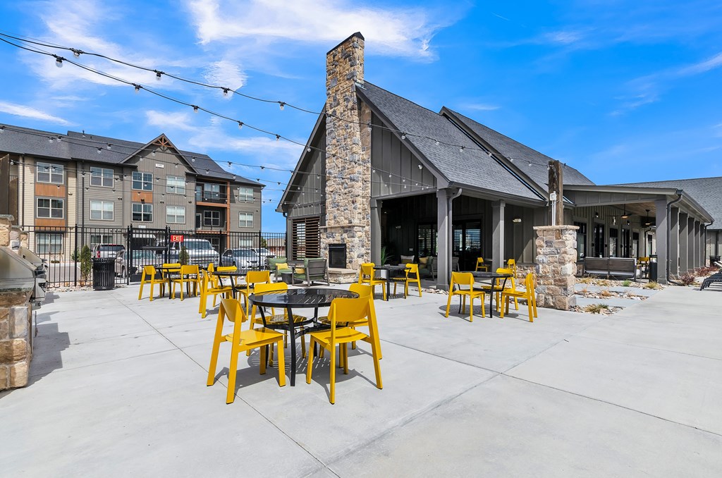 a patio with yellow chairs and tables and a fire pit at Apex, Colorado Springs