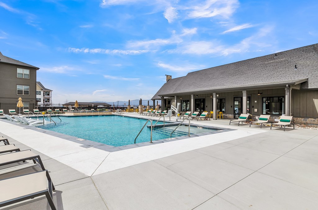 a pool with lounge chairs and a building in the background at Apex, Colorado Springs, Colorado