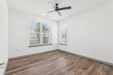 A room with a ceiling fan and two windows. at The Junction at Rockledge Apartments, Florida, 32955