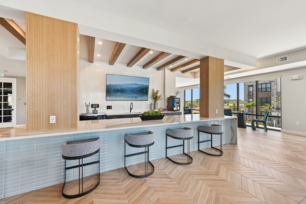 A kitchen with a bar area and a painting hanging above the counter at The Concord Luxury Apartments, Sarasota 34240