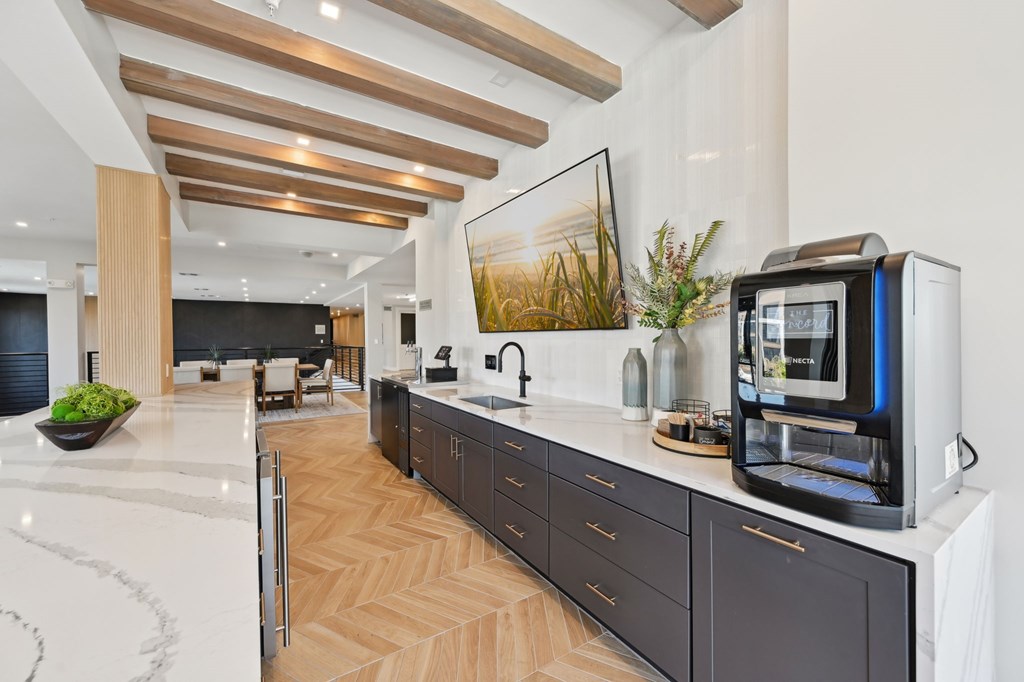 A modern kitchen with dark wood cabinets and a white countertop at The Concord Luxury Apartments, Sarasota, FL
