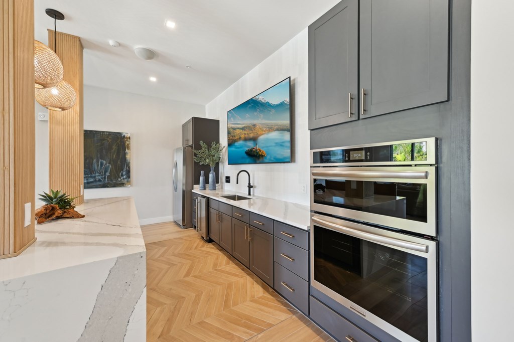 A modern kitchen with a marble countertop and stainless steel appliances at The Concord Luxury Apartments, Sarasota, FL, 34240