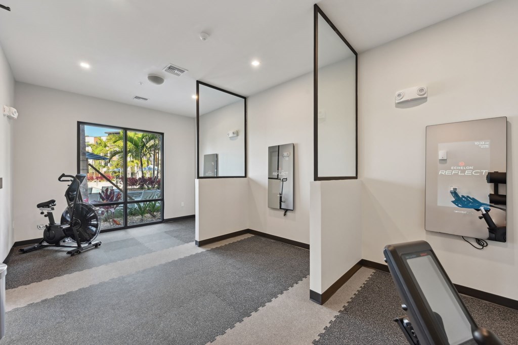 A room with a treadmill and a mirror on the wall at The Concord Luxury Apartments, Sarasota 34240