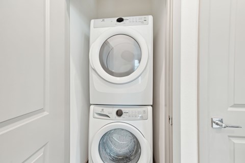 A white washing machine and dryer in a small laundry room at The Hadley - North Port, FL Apartments, North Port, FL, 34287