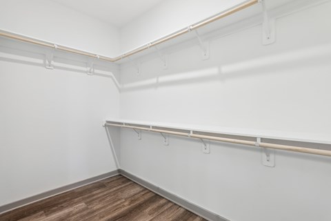 A room with white walls and wooden flooring with a long white pipe running along the wall. at The Junction at Rockledge Apartments, Rockledge, Florida