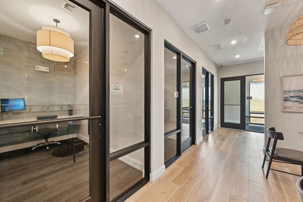A modern office space with glass walls and wooden floors at The Concord Luxury Apartments, Sarasota, FL, 34240
