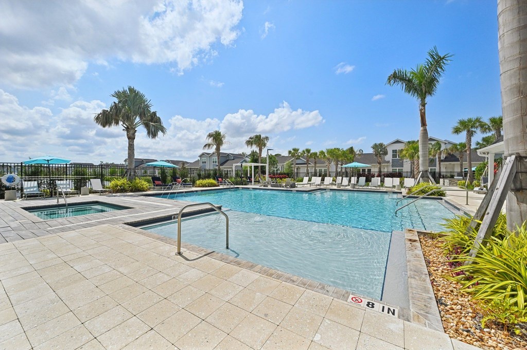 A swimming pool surrounded by palm trees and a clear blue sky. at The Sophia, Venice, FL, 34275
