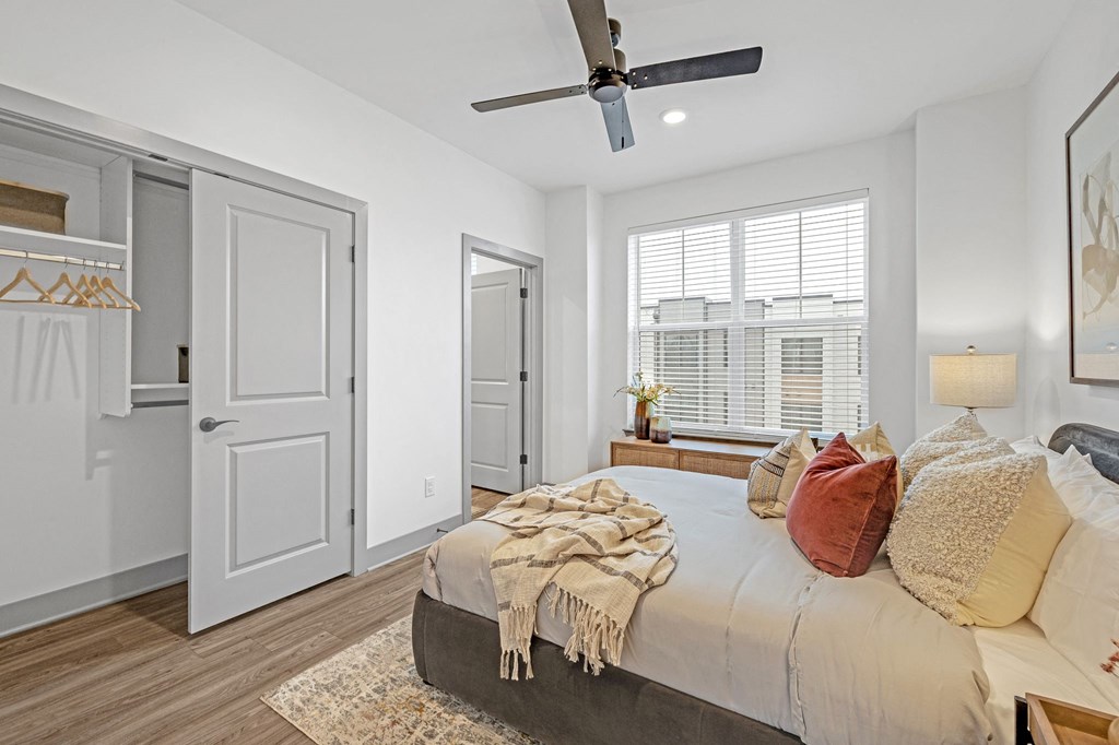a bedroom with a large bed and a ceiling fan at Meridian at CityPlace, Woodbury, MN 55125