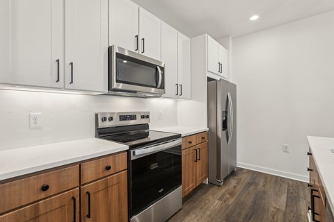 A kitchen with wooden cabinets and stainless steel appliances. at The Junction at Rockledge Apartments, Rockledge, FL