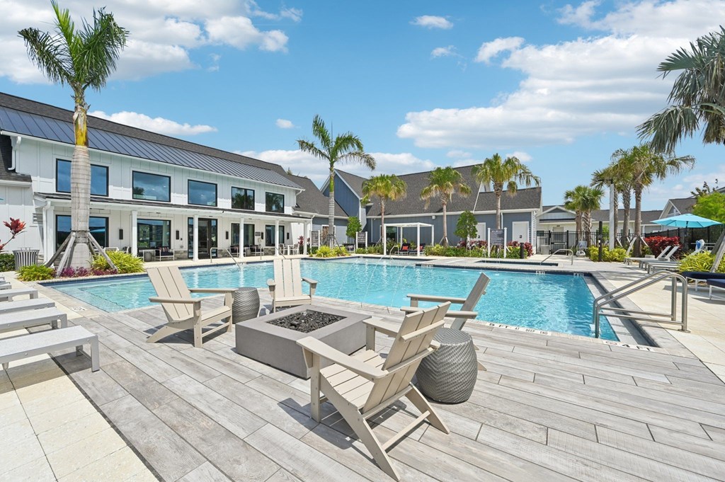 A pool area with chairs and a palm tree. at The Sophia, Venice, FL, 34275