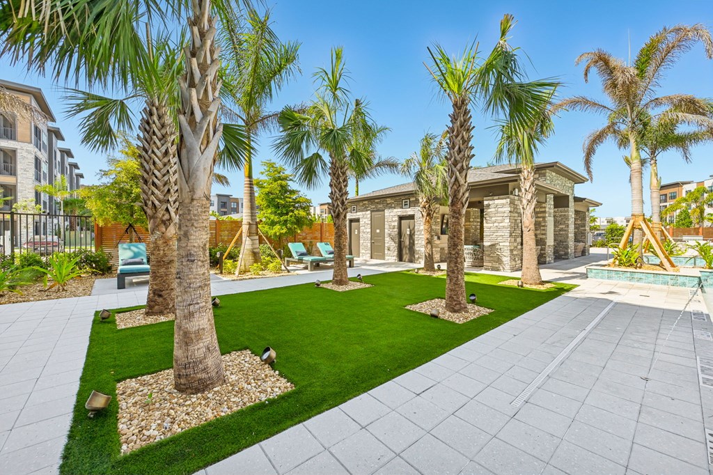 A row of palm trees are planted in a garden at The Concord Luxury Apartments, Sarasota