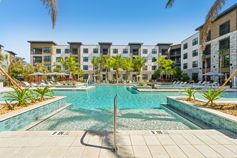 A swimming pool in front of apartment buildings.