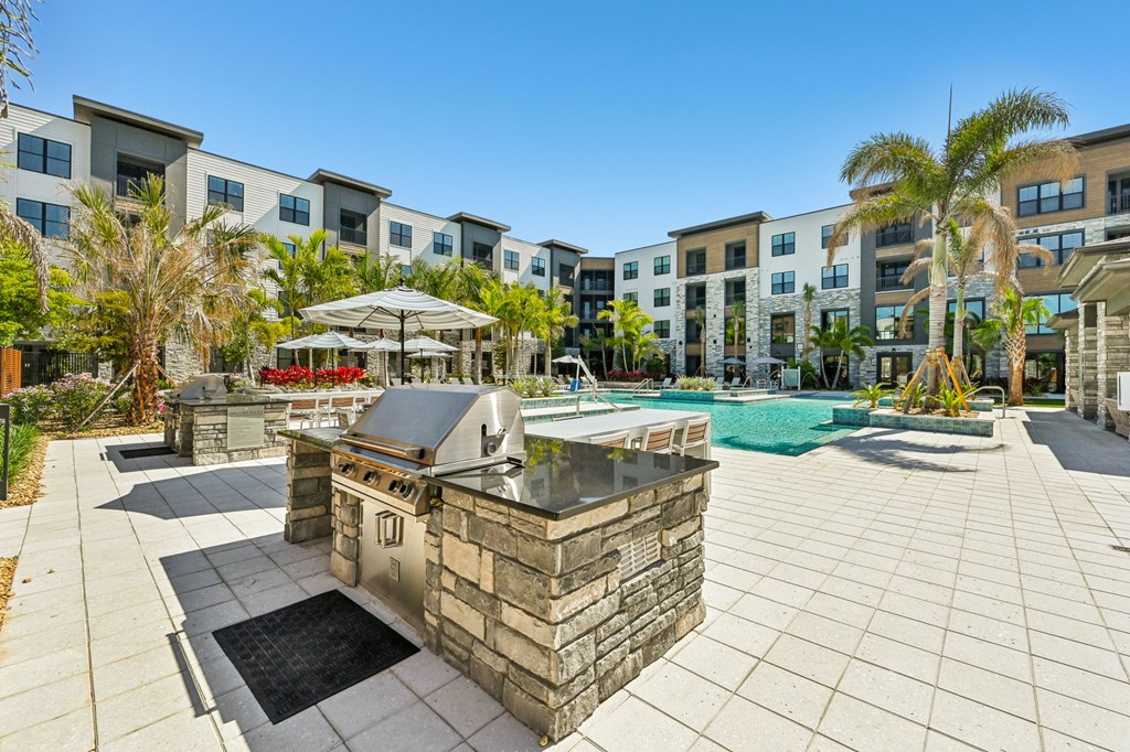 A pool area with a stone fountain in the middle of a patio at The Concord Luxury Apartments, Florida