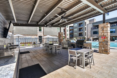 A patio with a table and chairs is covered by a roof.