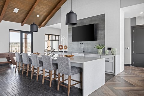 a kitchen with a marble counter top and a long island with chairs at Alta25, Monument