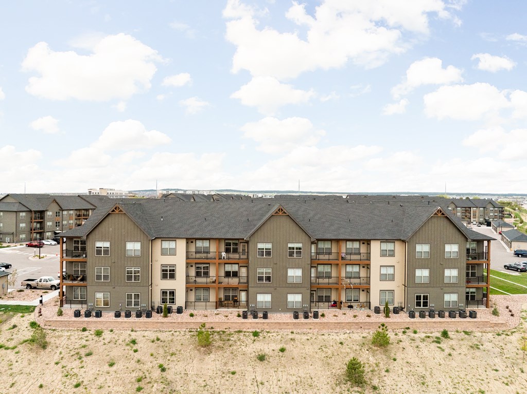 an aerial view of an apartment building on a dirt field
