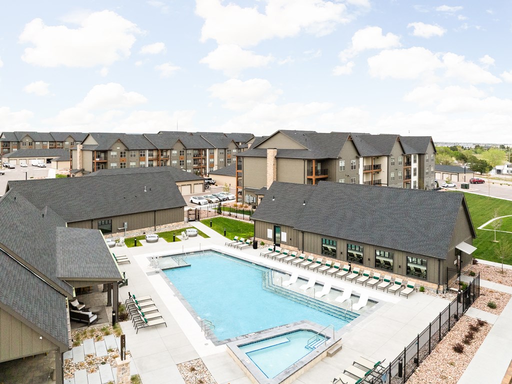 an aerial view of a swimming pool with apartments in the background