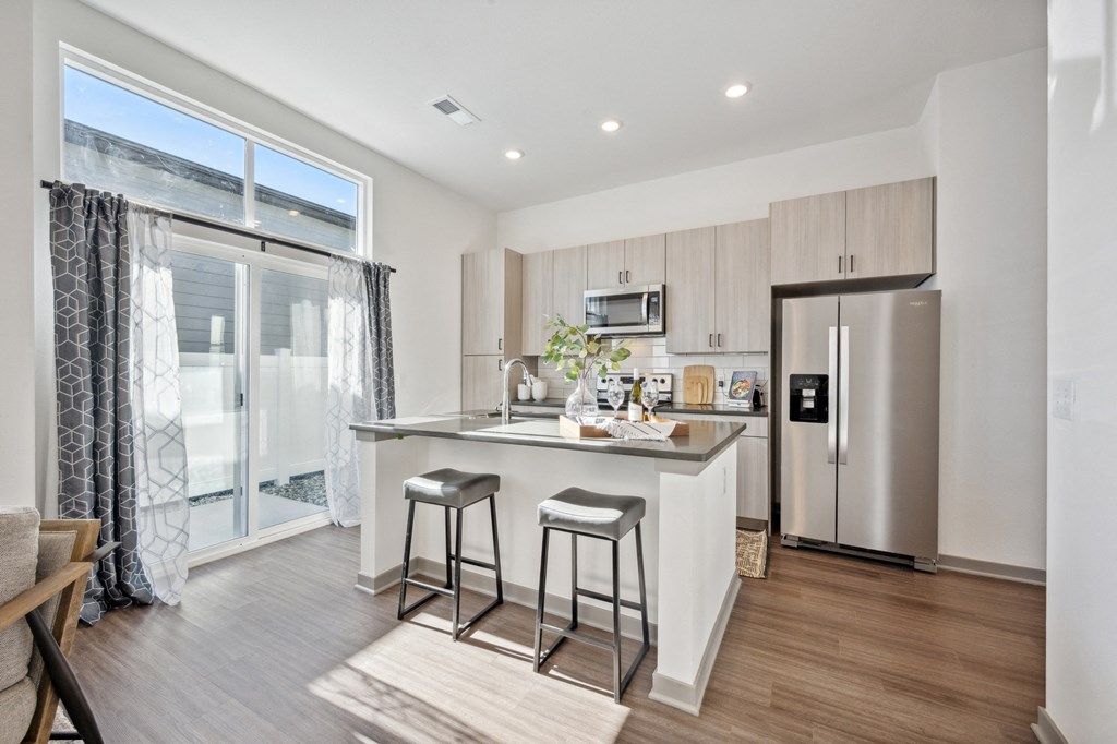 a kitchen with stainless steel appliances and a island with two stools at Citadel at Castle Pines, Colorado, 80108