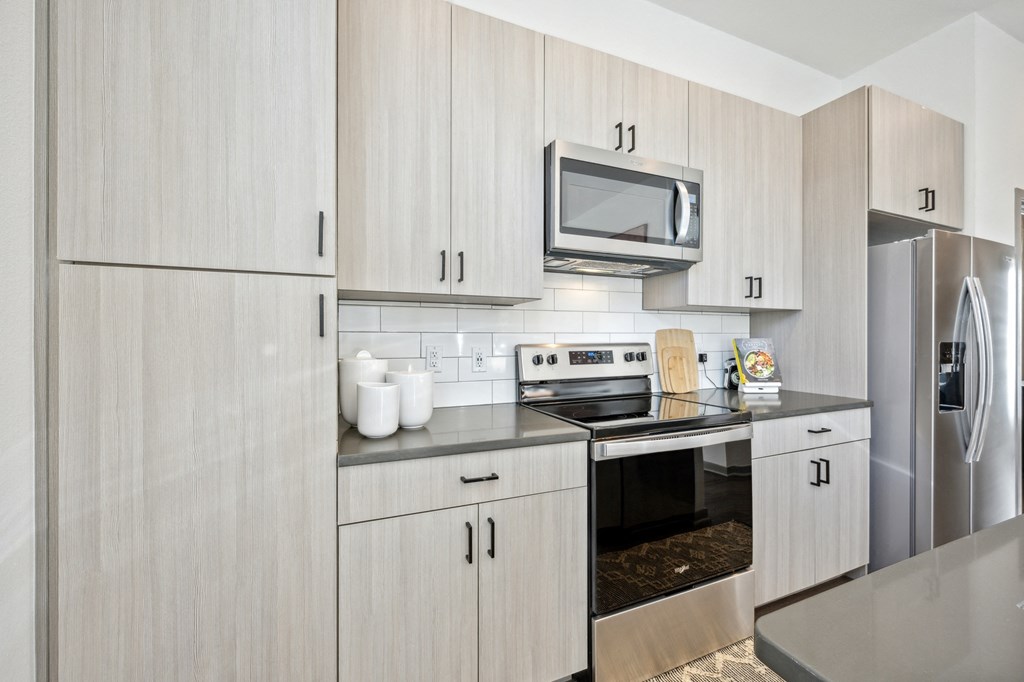 a modern kitchen with stainless steel appliances and white cabinets at Citadel at Castle Pines, Colorado