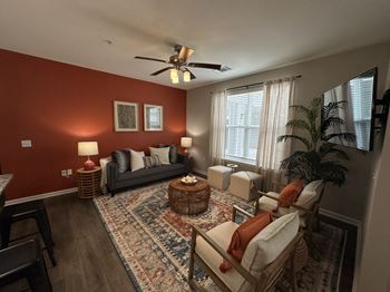 a living room with red walls and a ceiling fan at Watermark at Steele Crossing, Fayetteville, AR