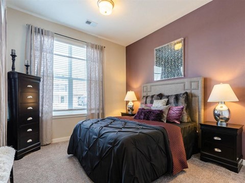 a bedroom with a bed and a dresser and a window