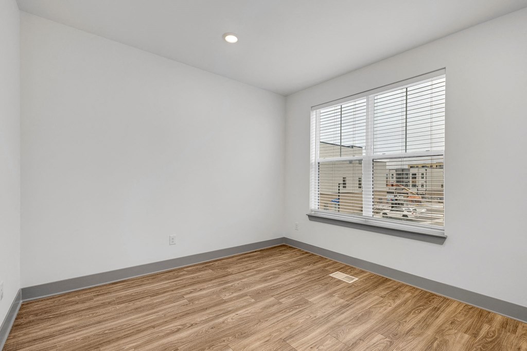 an empty room with wood flooring and a large window at Meridian at CityPlace, Woodbury, MN 55125