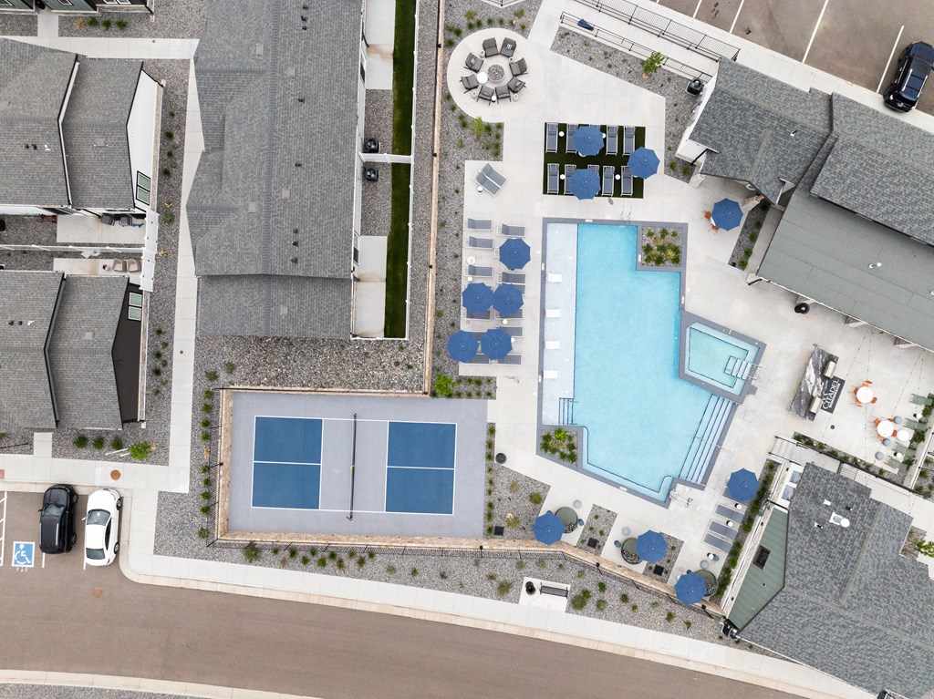 an aerial view of a yard with a pool and a parking lot