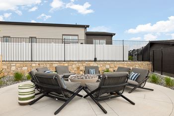 a patio with four chairs and a fire pit