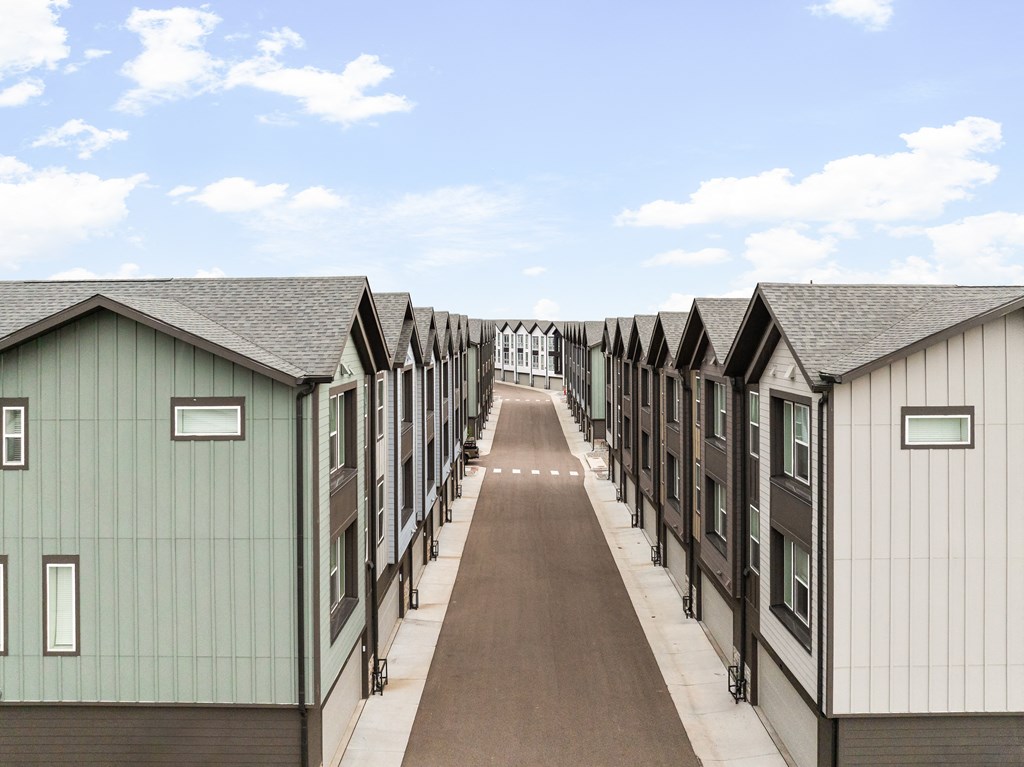 a row of small houses down a dirt road