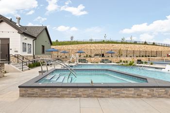 our resort style swimming pool is next to our pool house with umbrellas