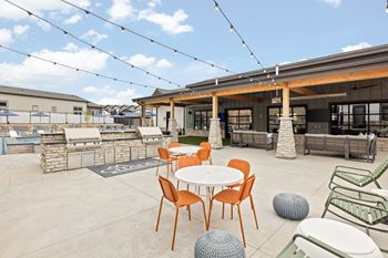a patio with tables and chairs and a building in the background
